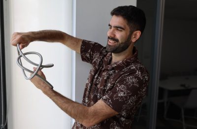 Evangelos holds up a twisted silver cord.