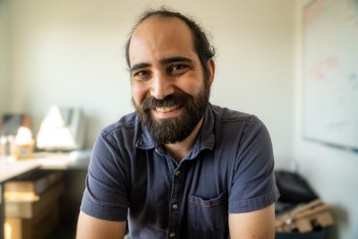 Man sits in his office smiling