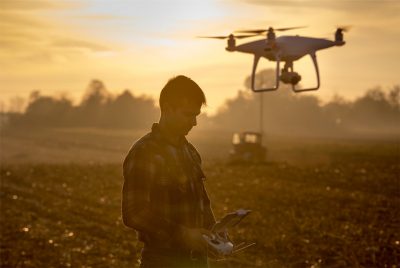 Man operating a drone in a field