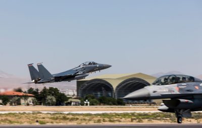 Two military jets taking off on a military base