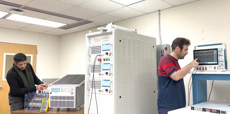 Two researchers lean over equipment in a lab